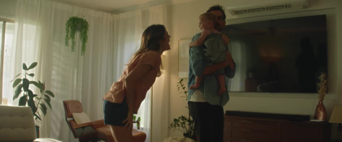 A father holding his daughter dancing around with the mother in their living room