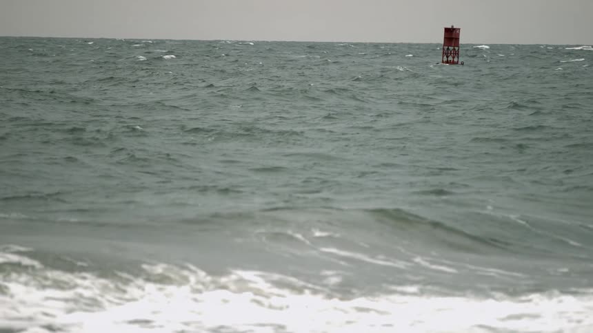 A buoy bobs on the ocean waves