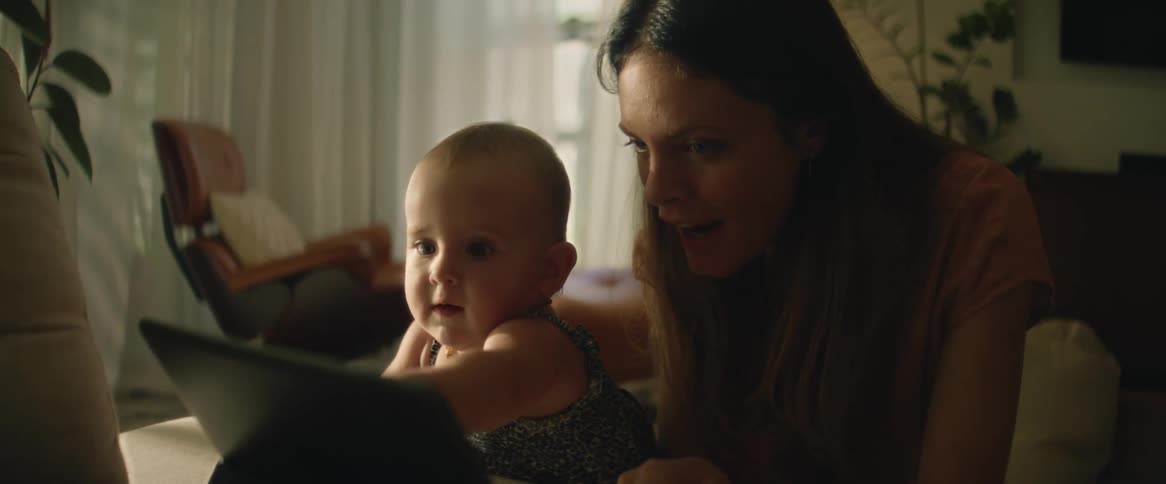 Mother teaches her daughter how to play with a tablet