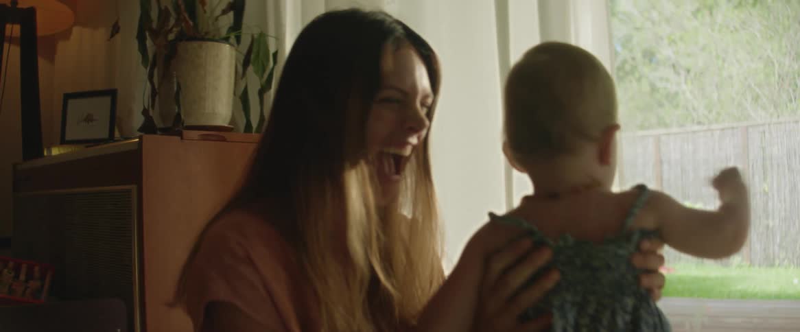 A mother and daughter playing indoor beside the window