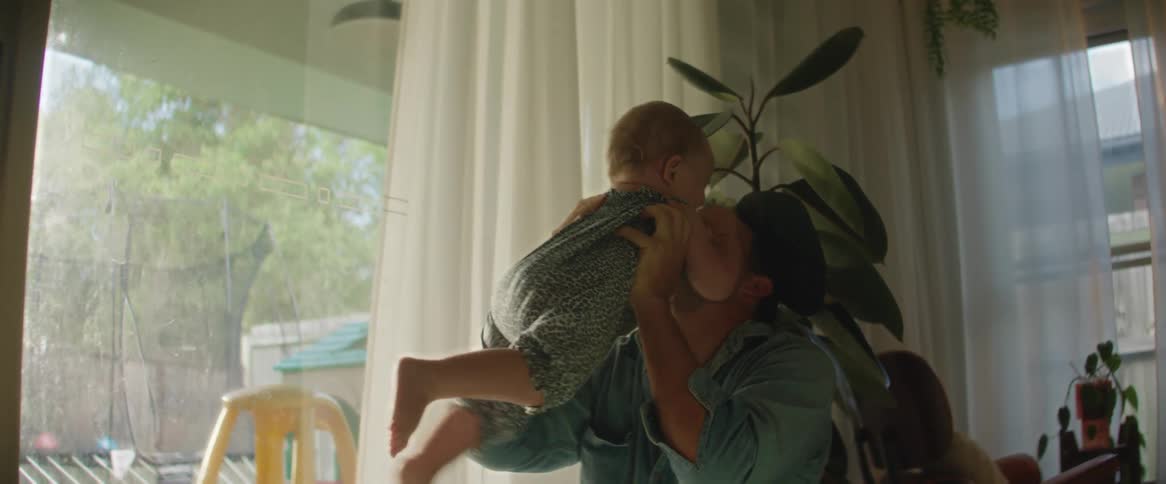 A father playing with his baby daughter and picking her up with a smile