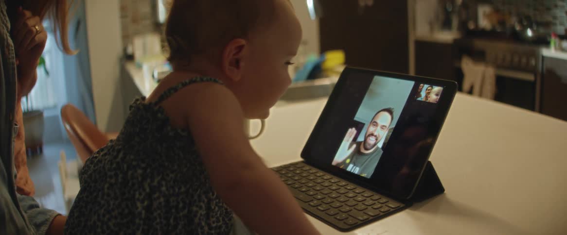 A child is talking to his father on a tablet