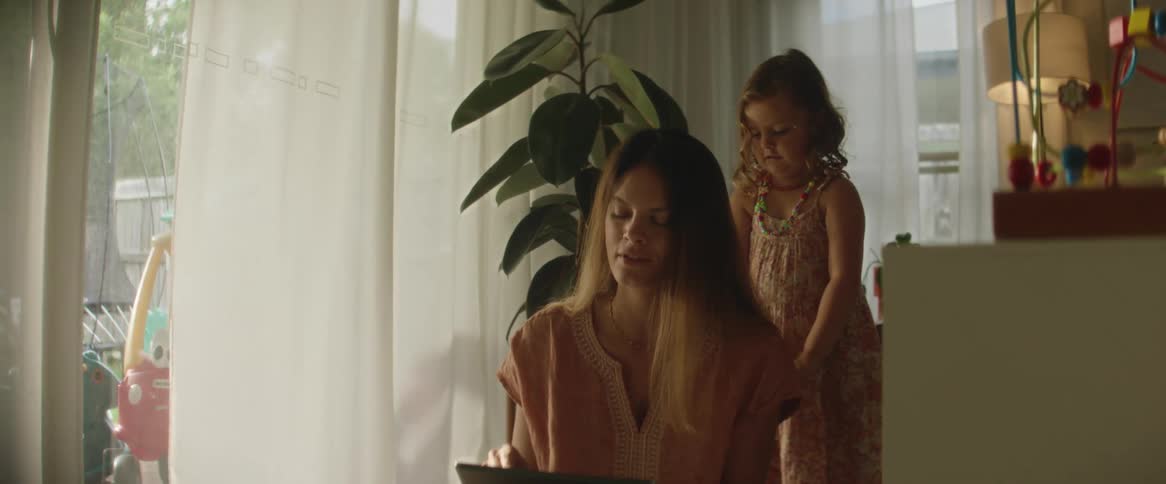 Mother sitting with her daughter playing with her hair