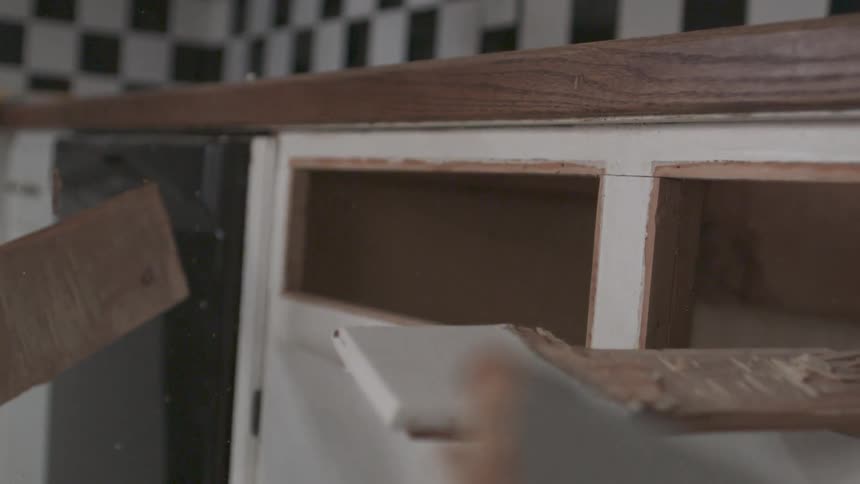 Hammer hitting cabinets in a kitchen