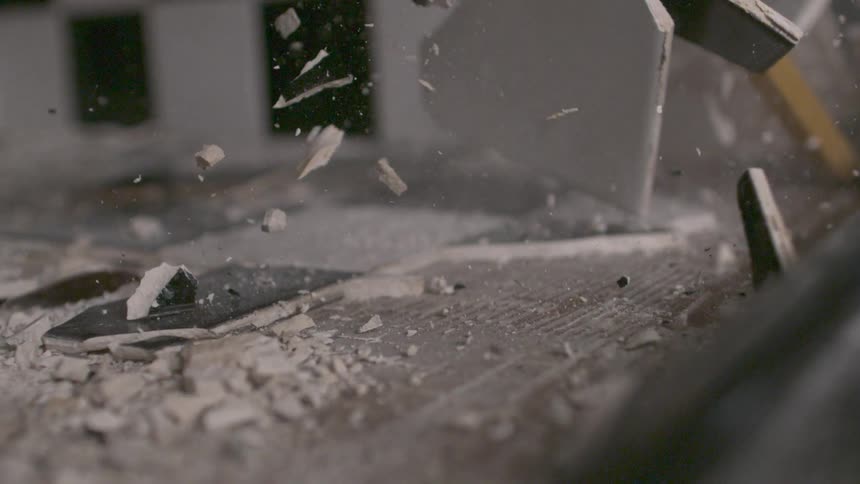 Countertop being destroyed by a scraping crowbar in slow motion