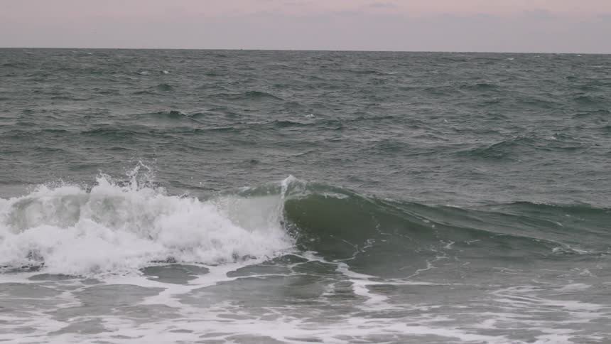 Small wave rolling ashore in slow motion