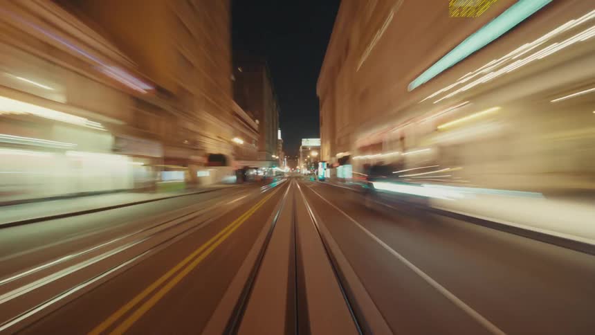 Timelapse pov footage of a vehicle driving on a city road at night capturing light trails