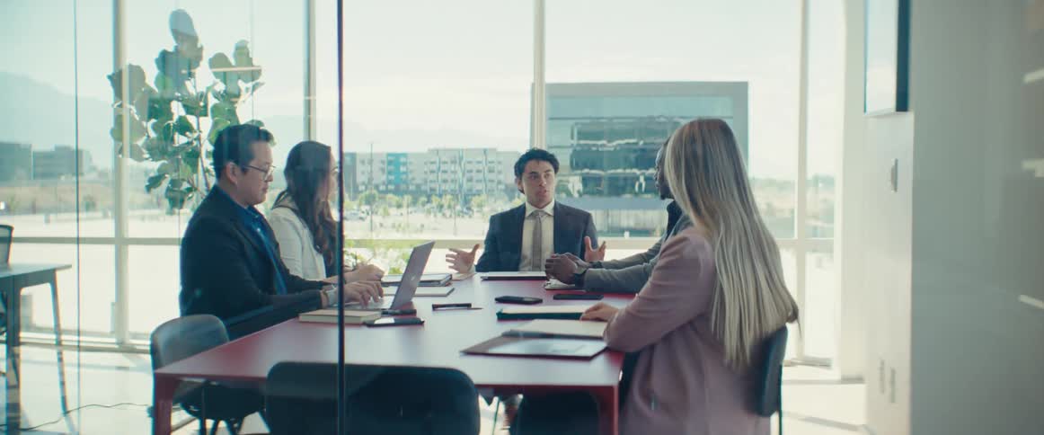 Group of people sitting at an office desk talking