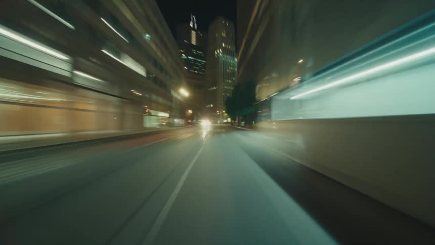 Streets of a metropolis illuminated at night seen in motion
