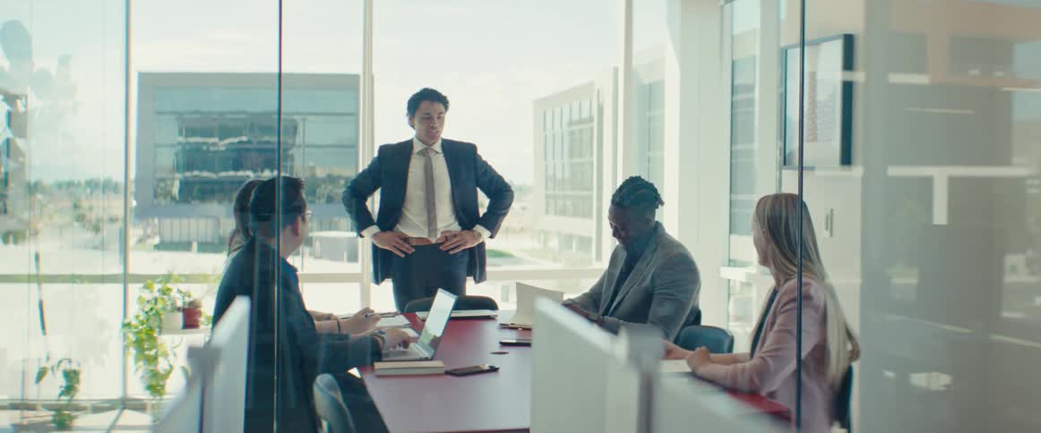 Man stands and talks during an office meeting near the outskirts of town
