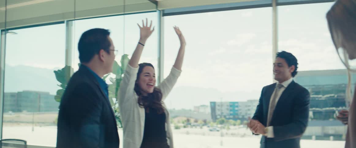 Colleagues in an office room celebrating and clapping