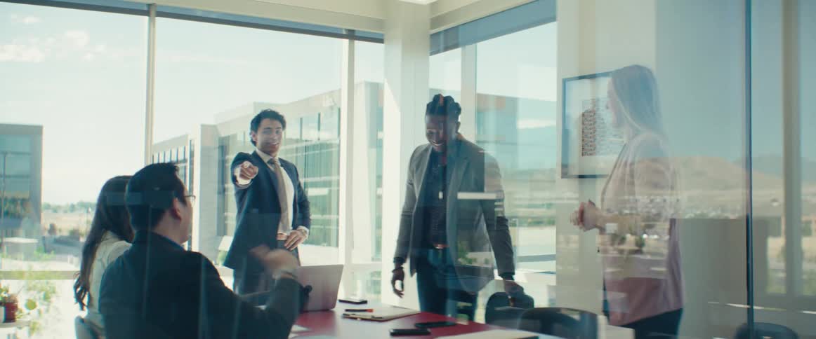 Men and women inside an office room talking and celebrating