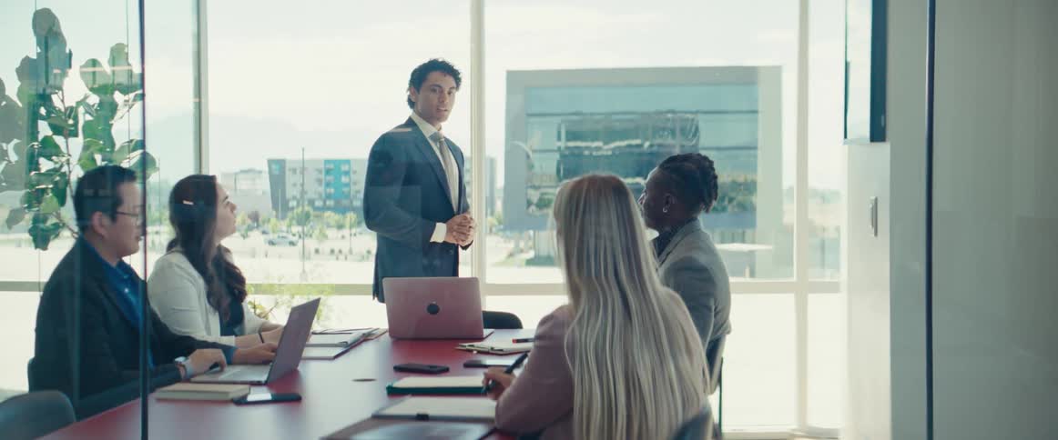 An asian man speaks to workers in an office