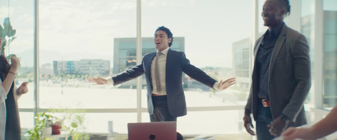 A group of people are wearing formal clothes and are dancing happily while talking in front of a table