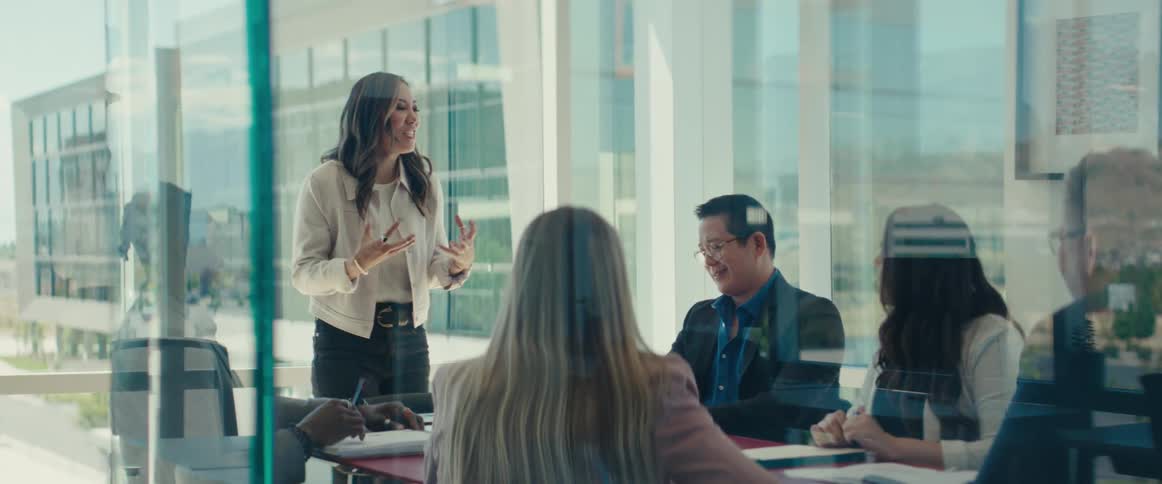 Woman standing in an office meeting with other people