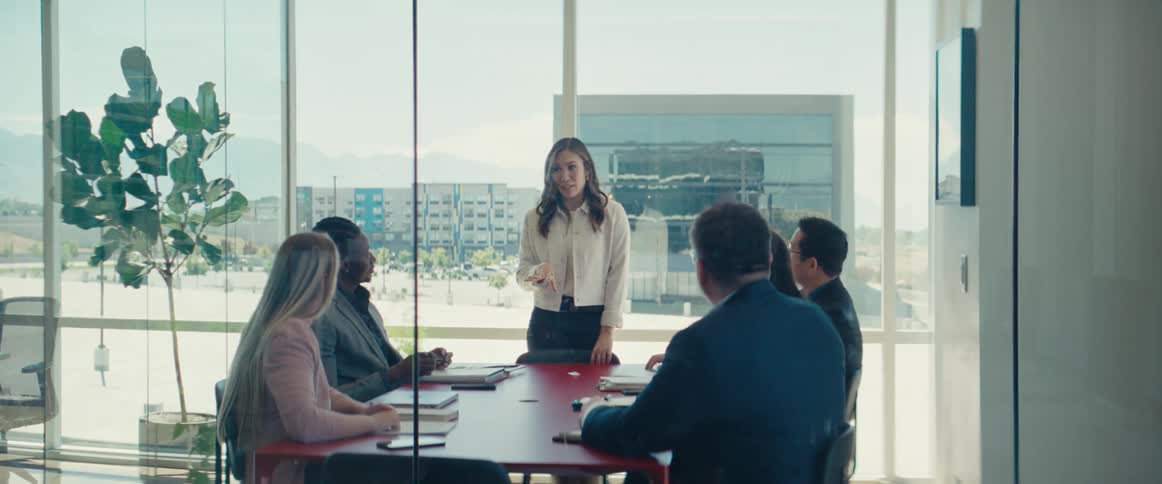 Woman standing talking to other colleagues in an office room