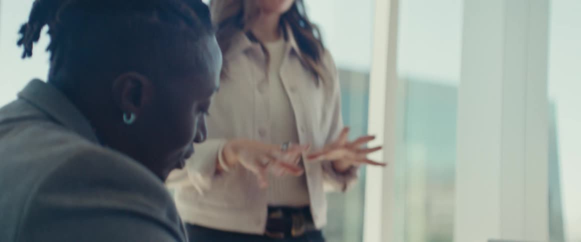 Colleagues gathered around a table in a modern office with large windows in a business meeting