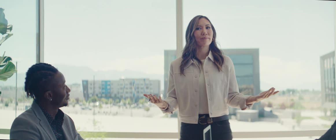 Woman standing talking at a table with other people in an office room