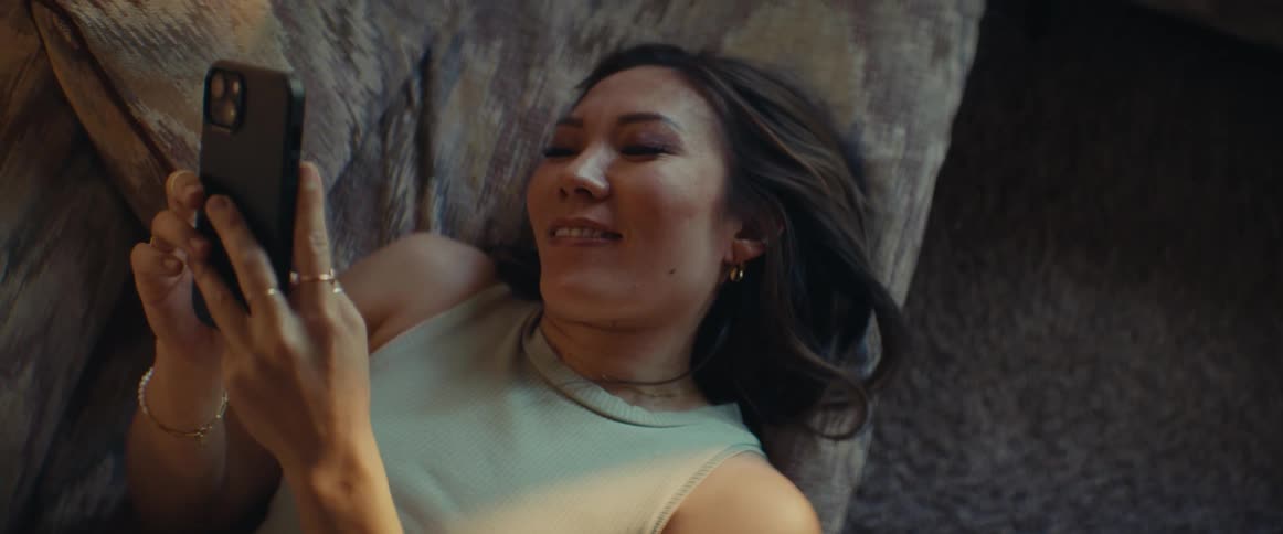 A clip of a female texting with the her smartphone while laying on the bed