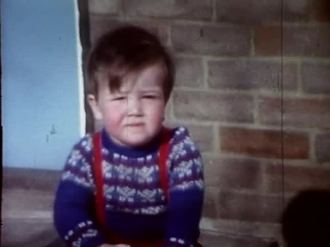 A frustrated toddler rides a toy horse