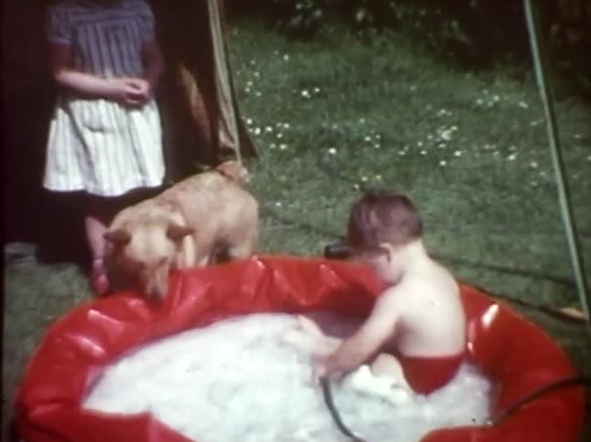A toddler playing in a red inflatable pool