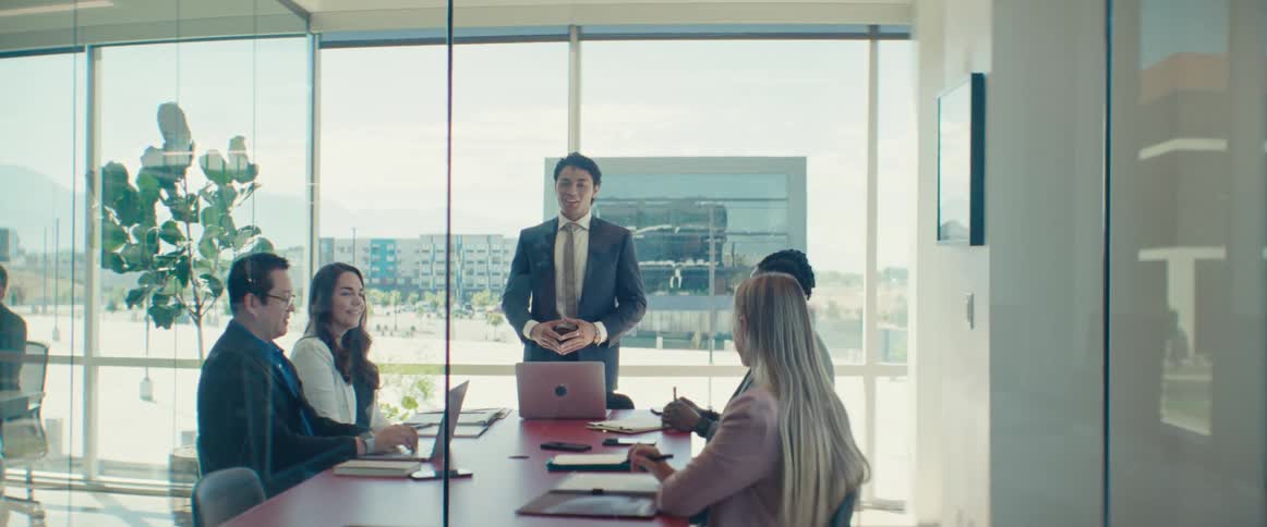 A hispanic man gives a presentation to his colleagues in an office setting
