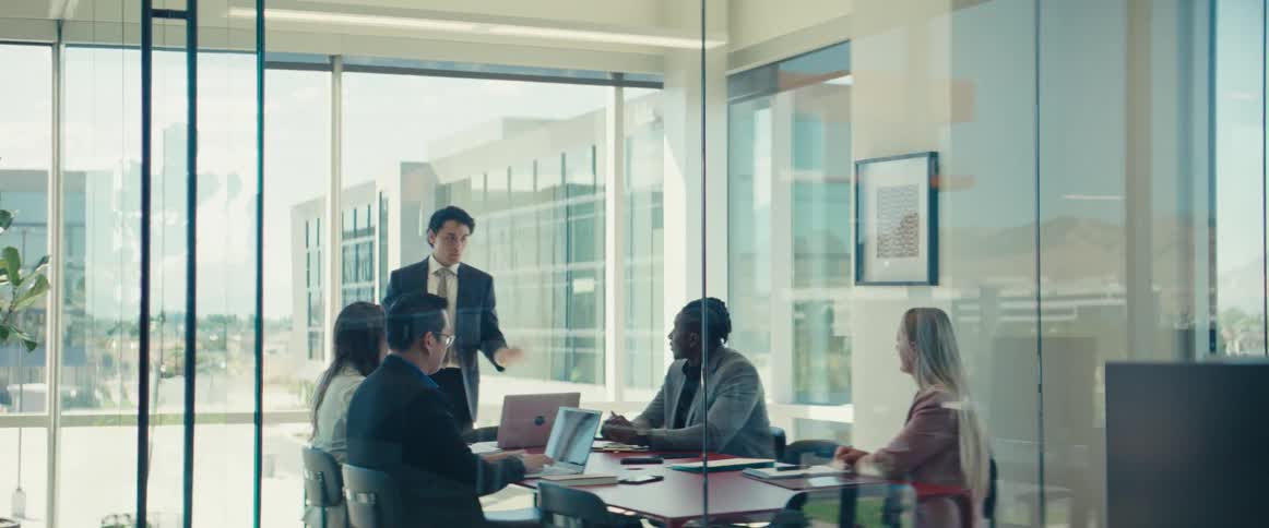 A hispanic man gives a presentation to his colleagues in an office setting