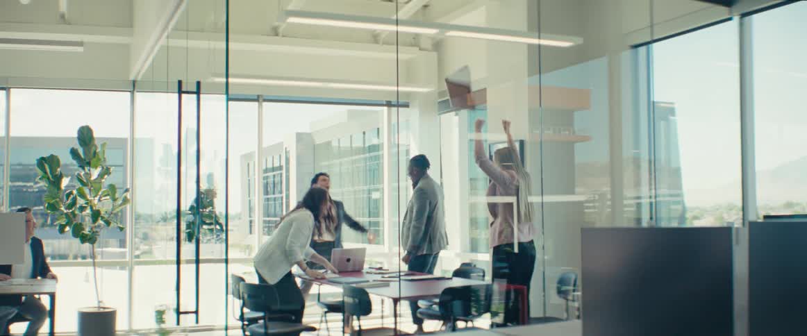 People inside an office room celebrating by throwing papers in the air
