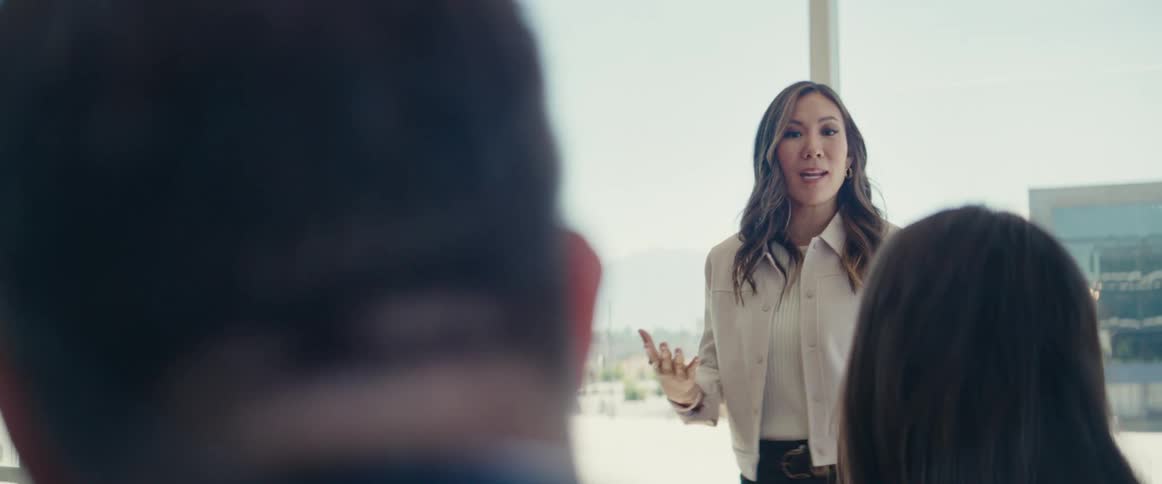 Woman standing talking to people in an office