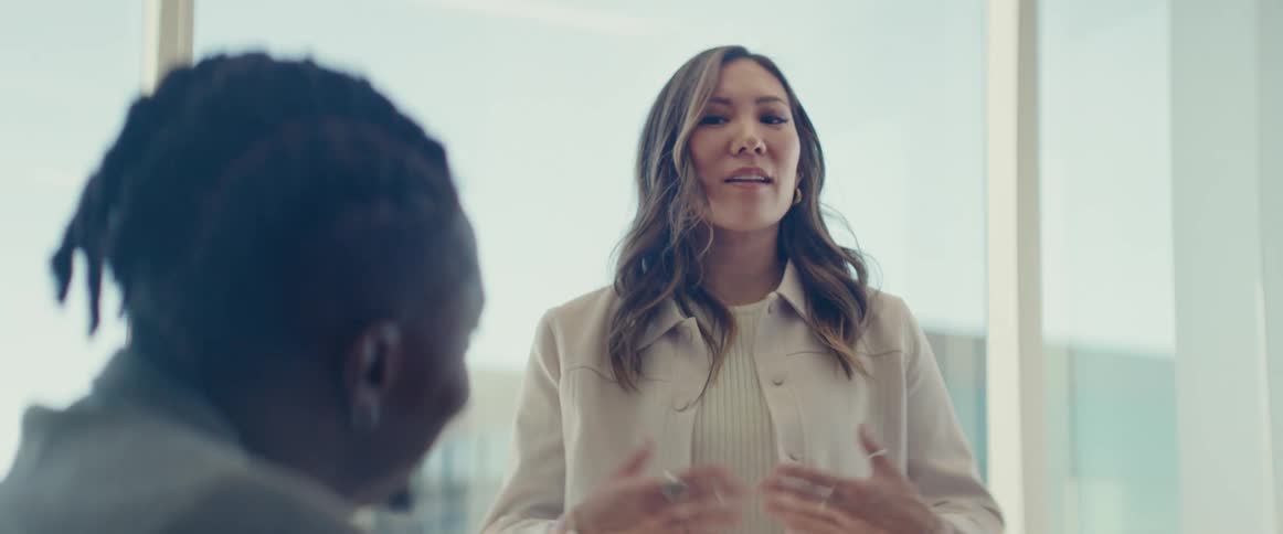 Two coworkers have a discussion at the office