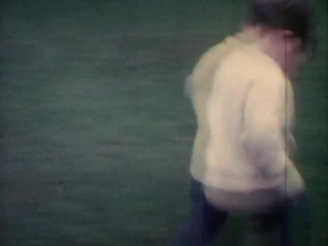 Young boy runs across the lawn and falls over