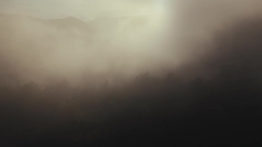 A misty landscape with sunlight illuminating the fog