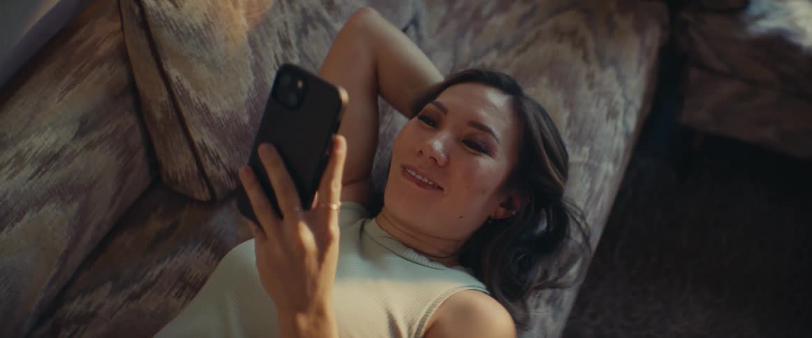 A clip of a lady operating her smartphone on the couch