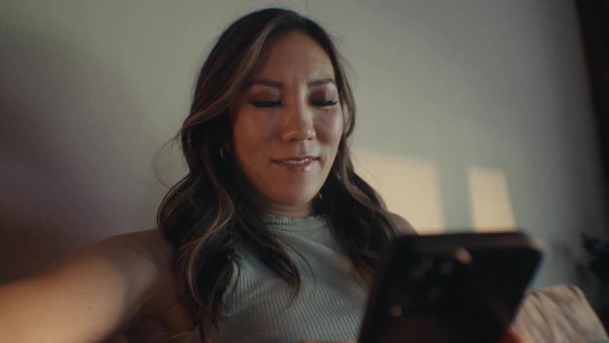 Woman sitting interacting and typing on an iphone
