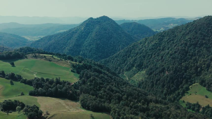 Aerial of forested mountains and hills on a summer day