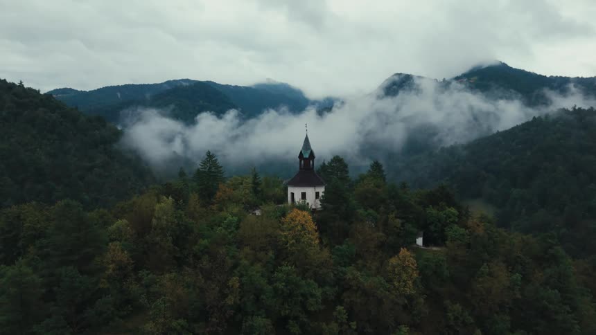 An aerial shot of a house in a forest