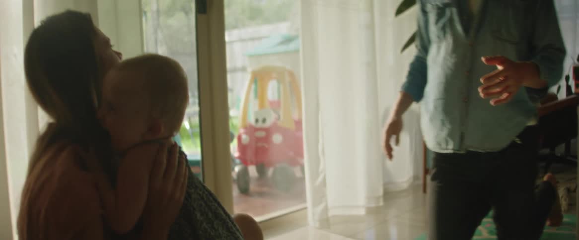 A clip of a father and a mother playing with their daughter indoor