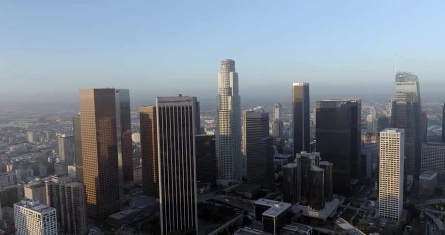 Aerial of skyscrapers on a city skyline in the middle of the day with blue skies in the background