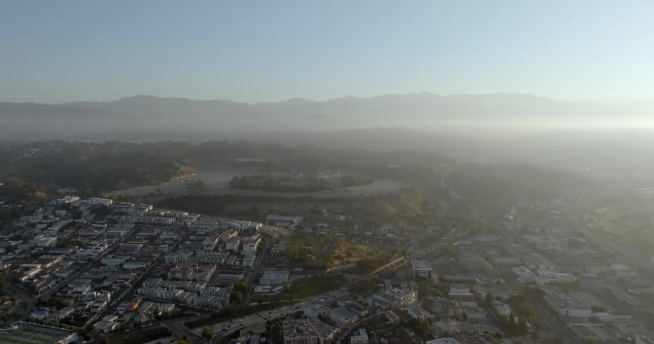 Aerial panorama of a metropolis with mountains on the horizon on a blue sky day