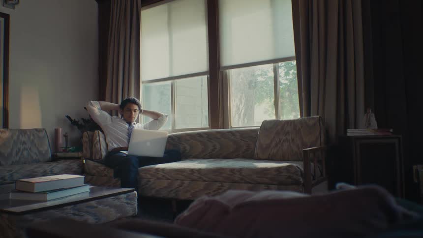 Man sitting in a living room with a laptop