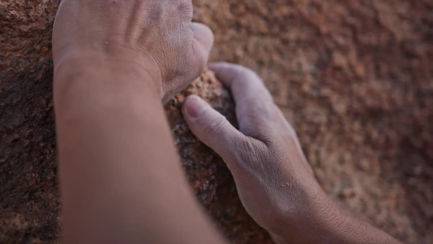 Close up of a persons hands with magnesium stuck to a rock