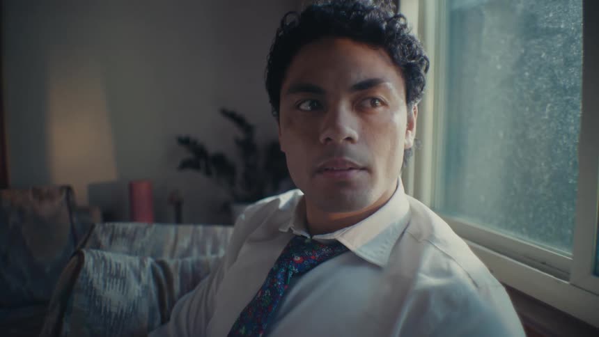 A clip of a man sitting beside the window