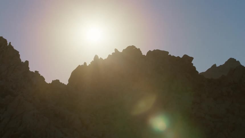 The top of a rough rock formation with strong sunlight streaming in from above