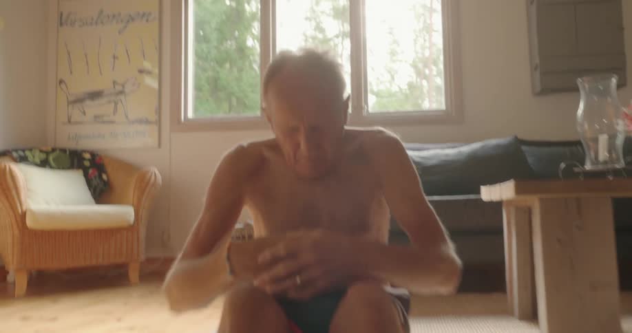 Elderly man doing abs workout lying on the mat