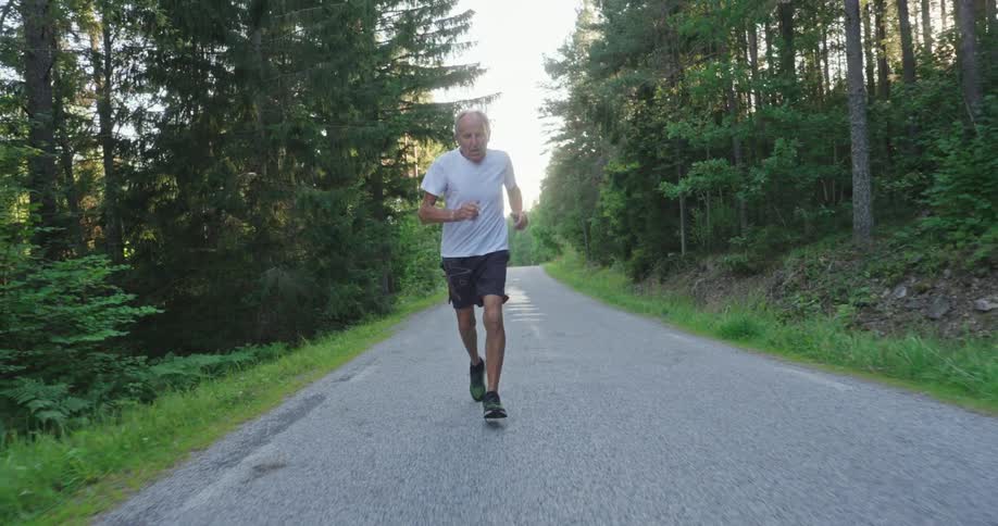 Elderly man running in a natural environment