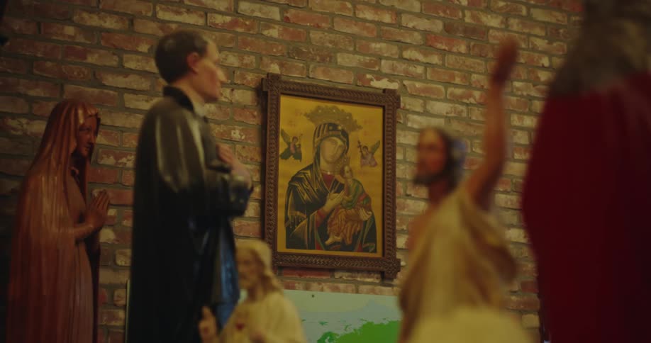 A painting of a saint on a brick wall surrounded by religious statues