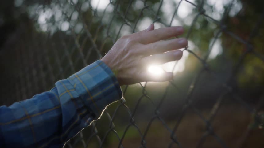 A persons hand running its fingers over a metal grate