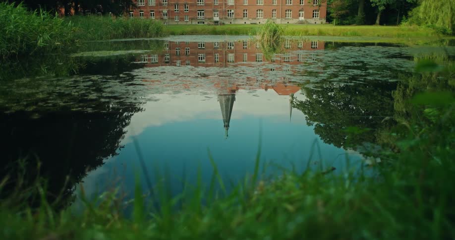 Algae covers part of the small pond reflecting alarge church spire