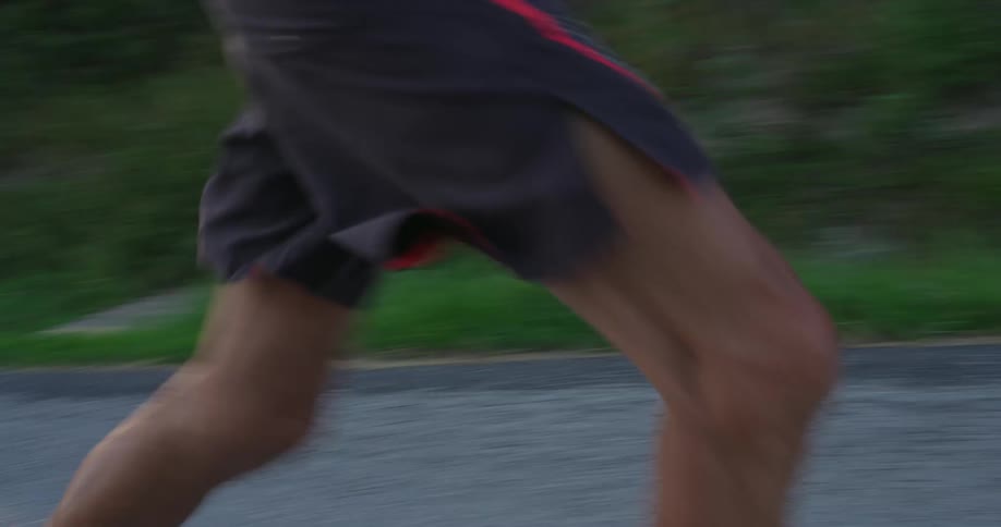 An elderly man runs along a rural road in a forested area