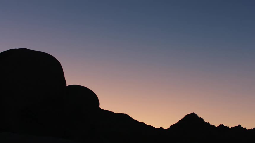 The silhouette of a mountain range at dusk